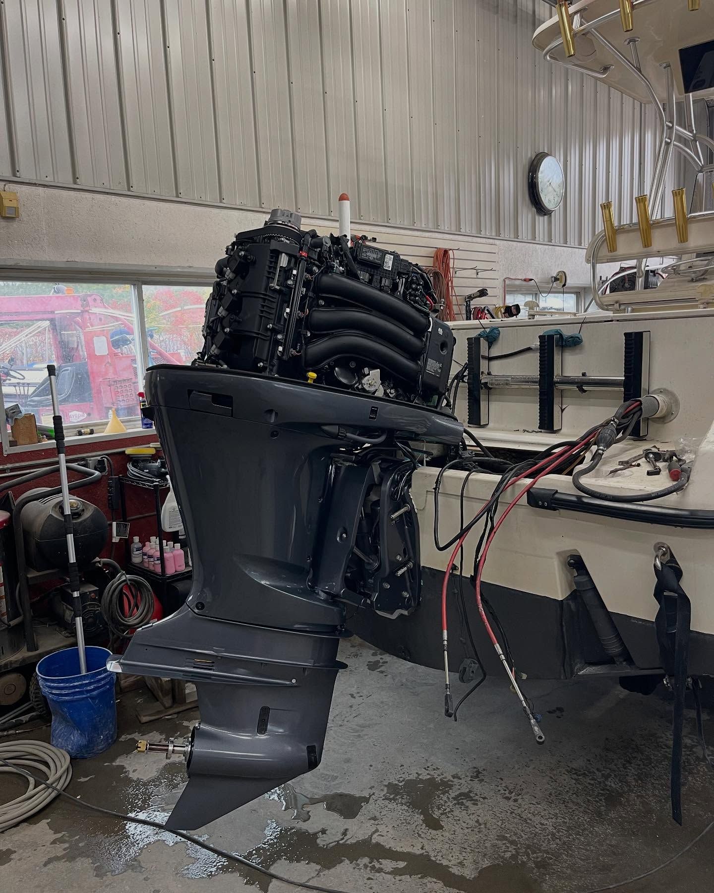 A boat engine is sitting on top of a boat in a garage.