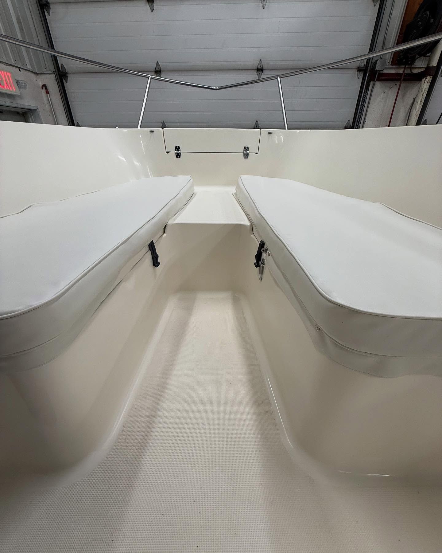 The inside of a boat with two seats and a garage door.
