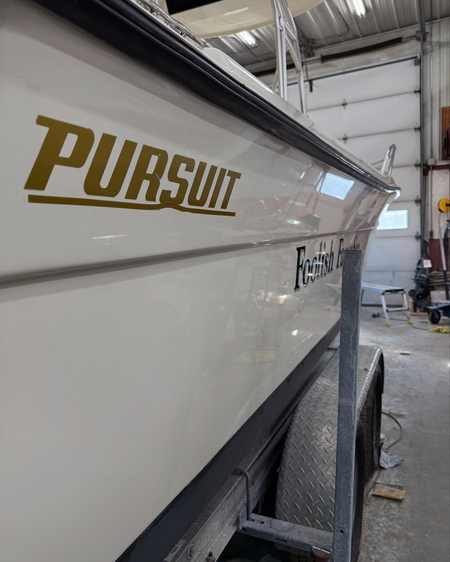 A white boat with the word pursuit on it