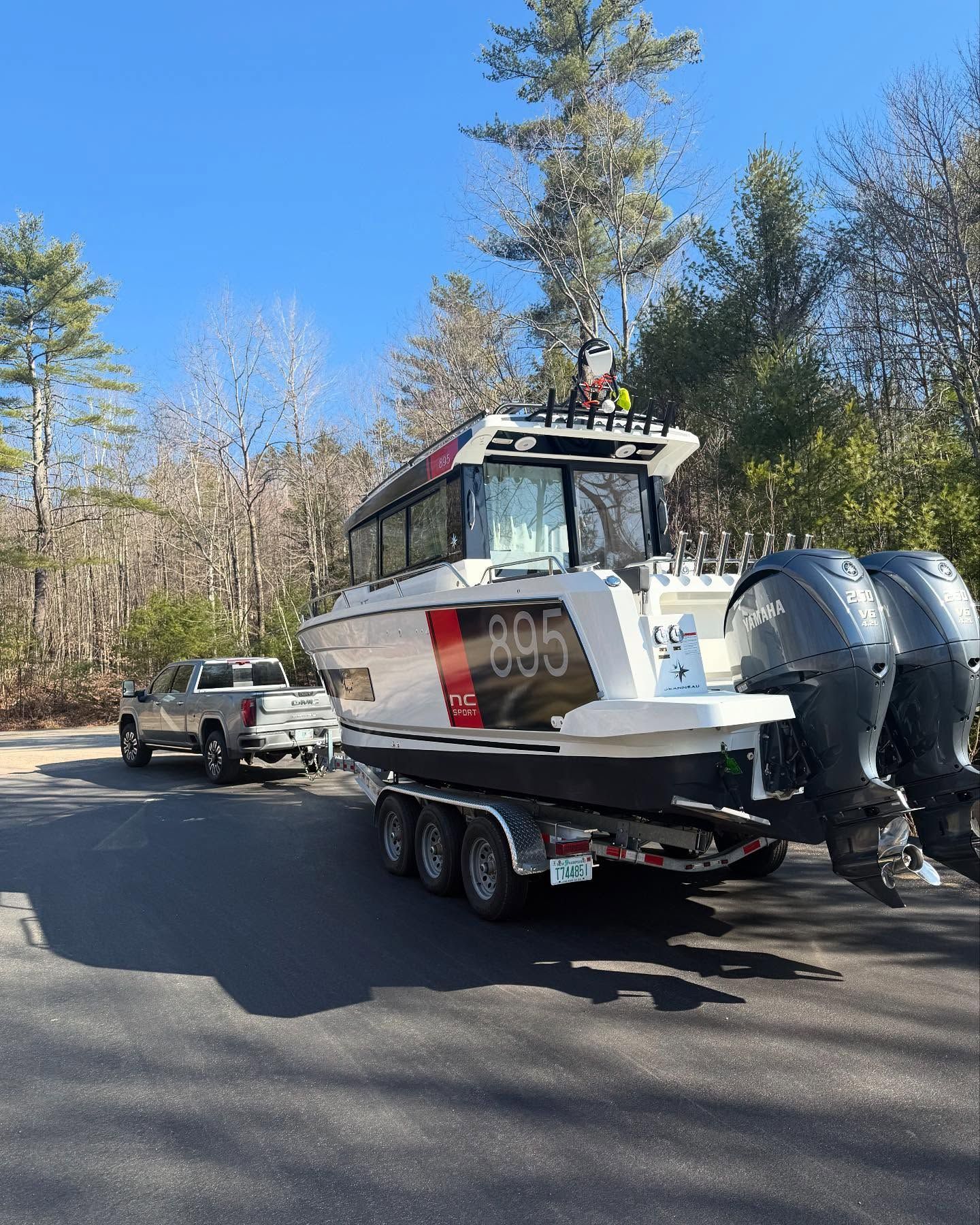 A boat is being towed by a truck on a trailer.
