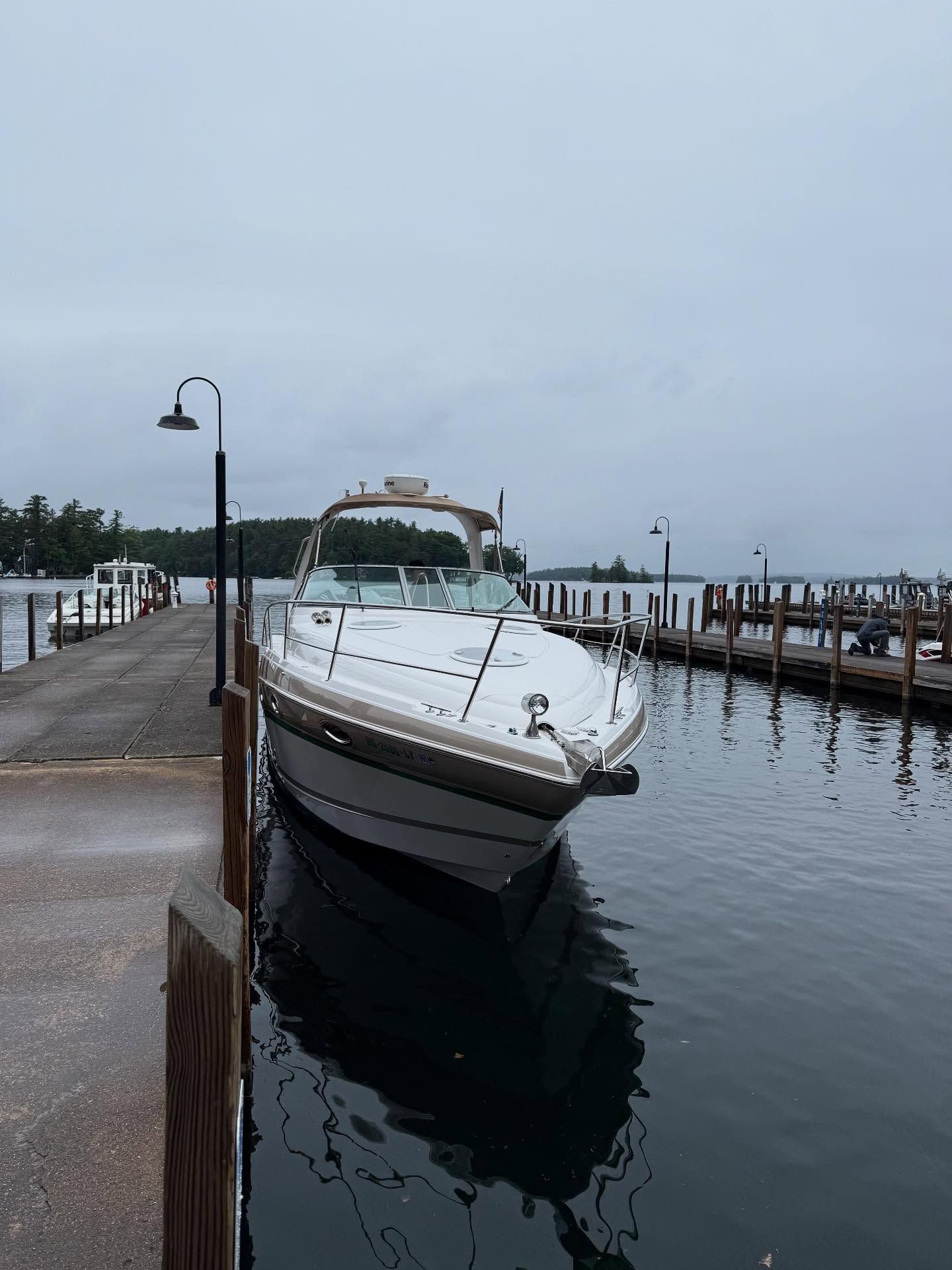 A boat is docked at a dock on a cloudy day