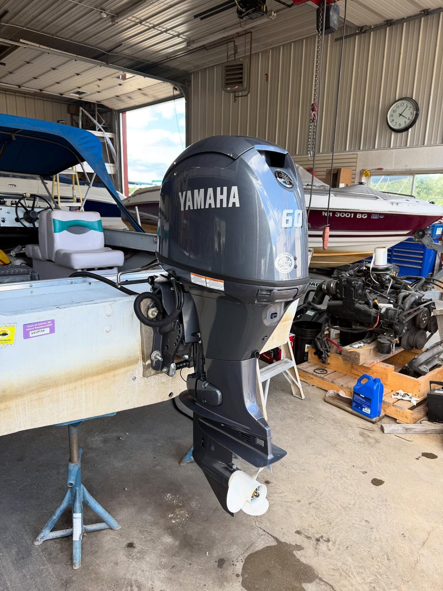 A yamaha outboard motor is sitting on top of a boat in a garage.