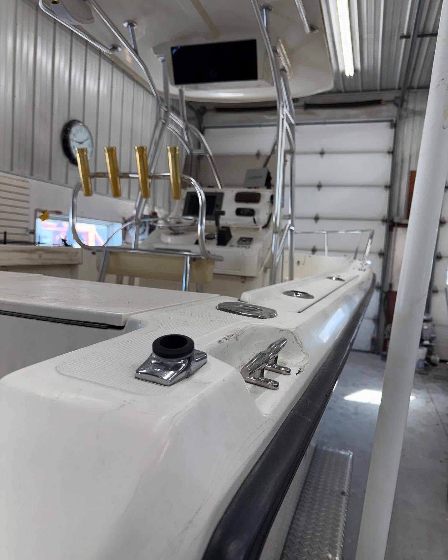 A boat is sitting in a garage next to a garage door.