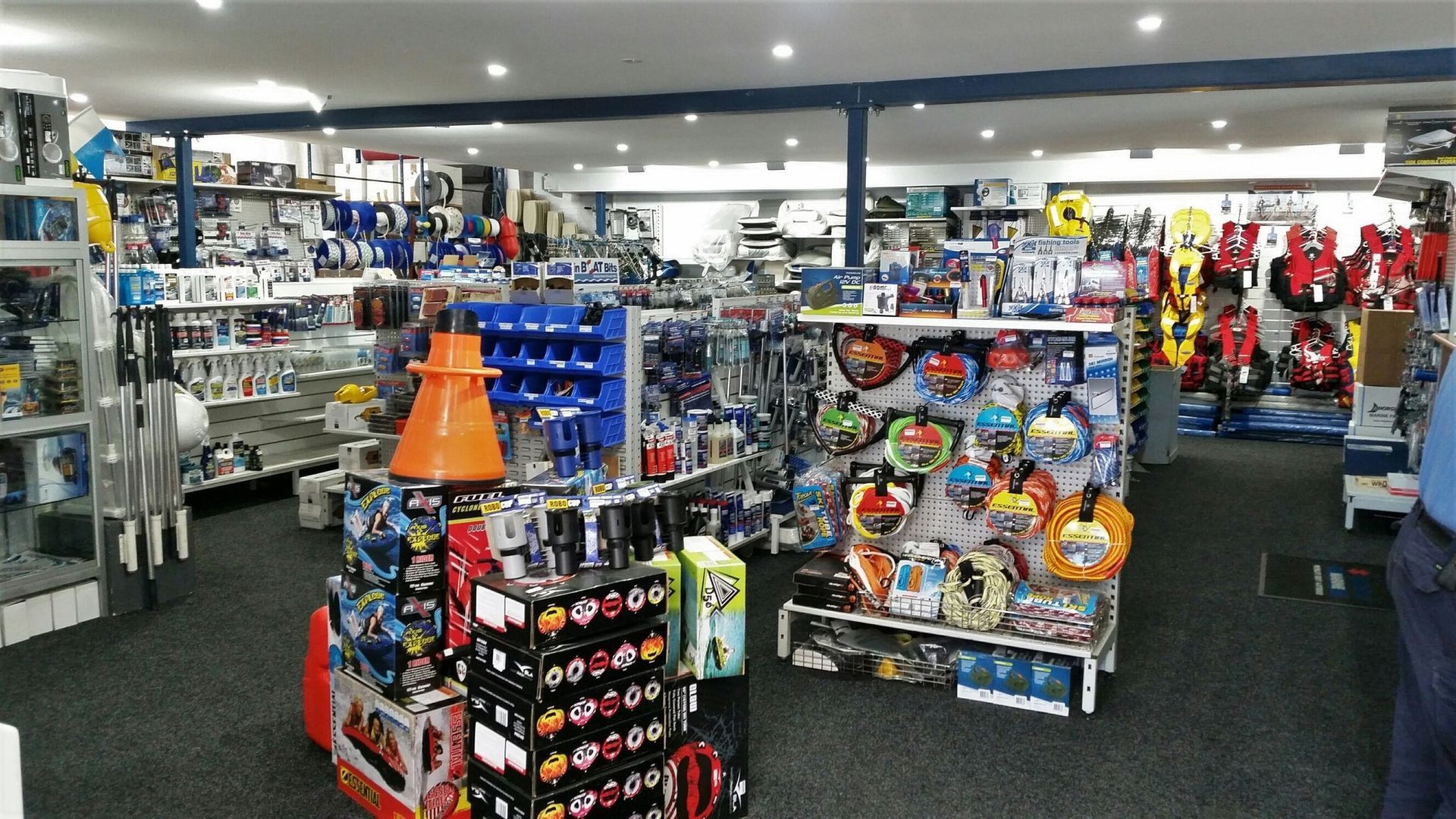 A man is standing in a store filled with lots of toys.