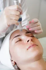 A woman is getting a facial treatment at a beauty salon.