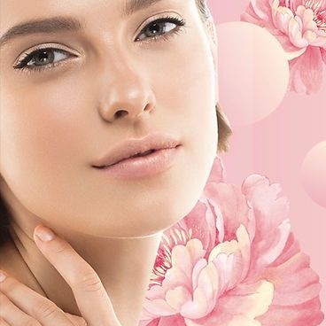 A close up of a woman 's face with pink flowers in the background.