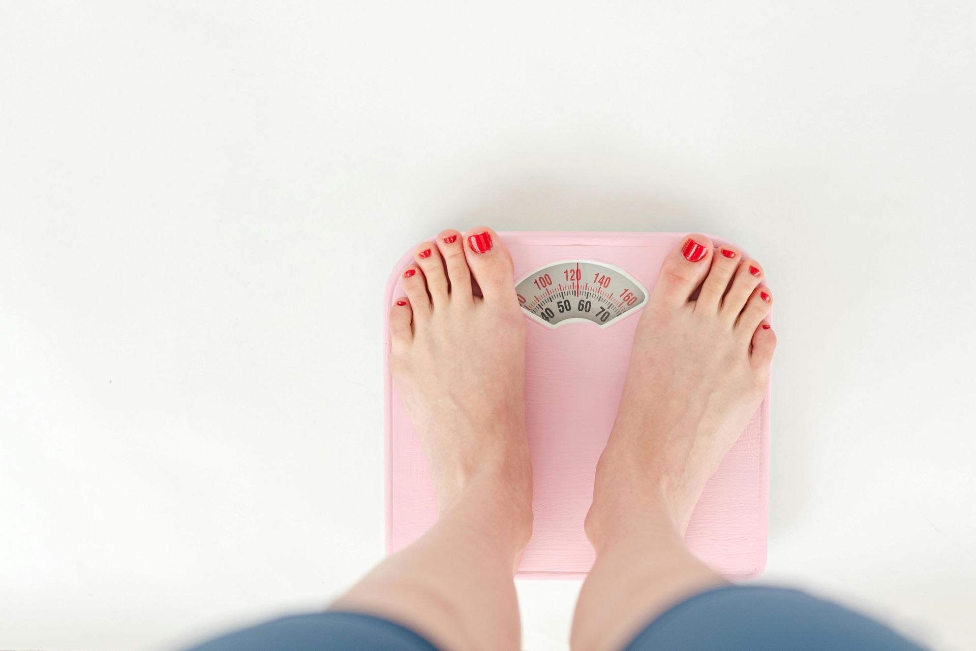 A woman is standing on a pink scale.