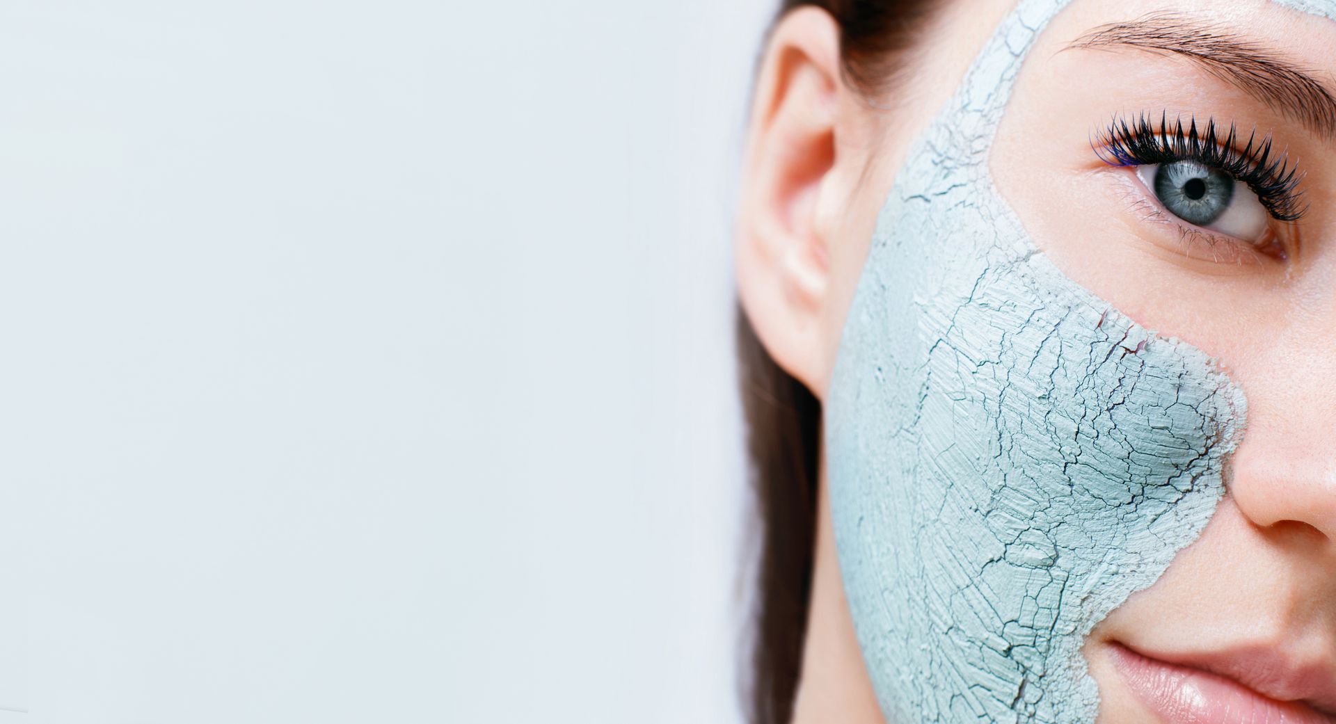 Woman with light blue face mask on half of her face.