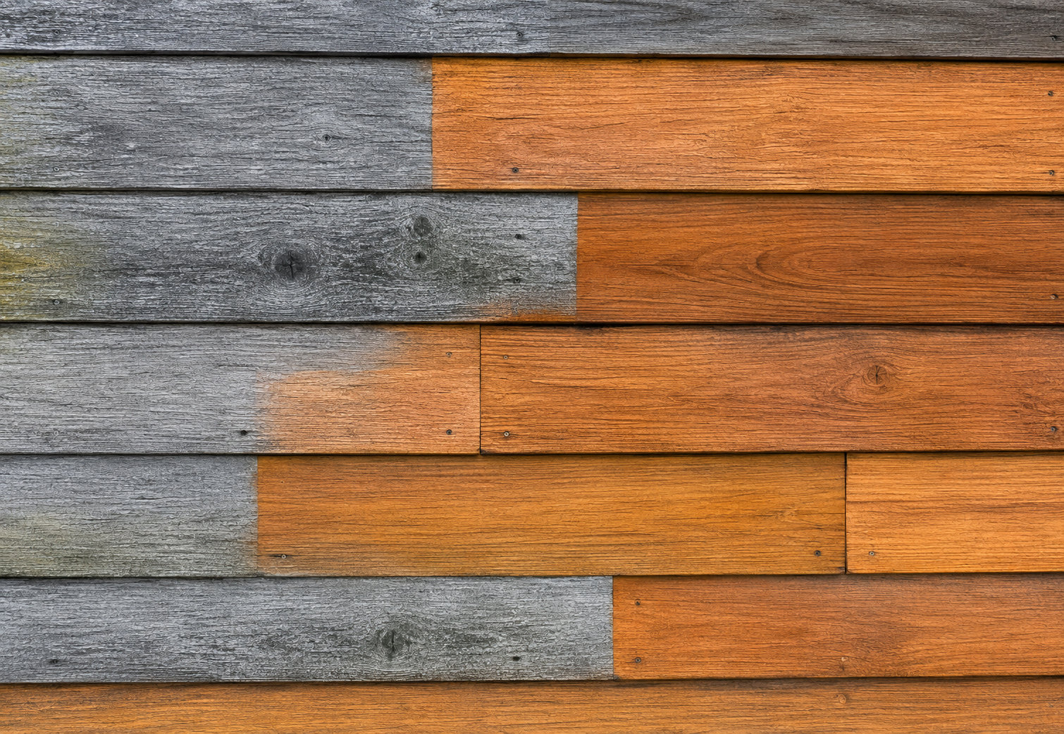 Weathered gray and orange wooden planks arranged in horizontal staggered rows