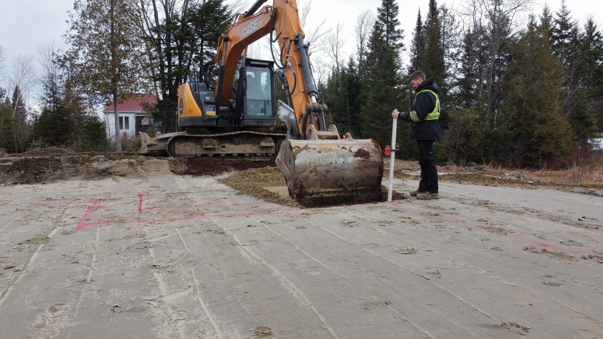 Un homme se tient à côté d’un bulldozer sur un chantier de construction.