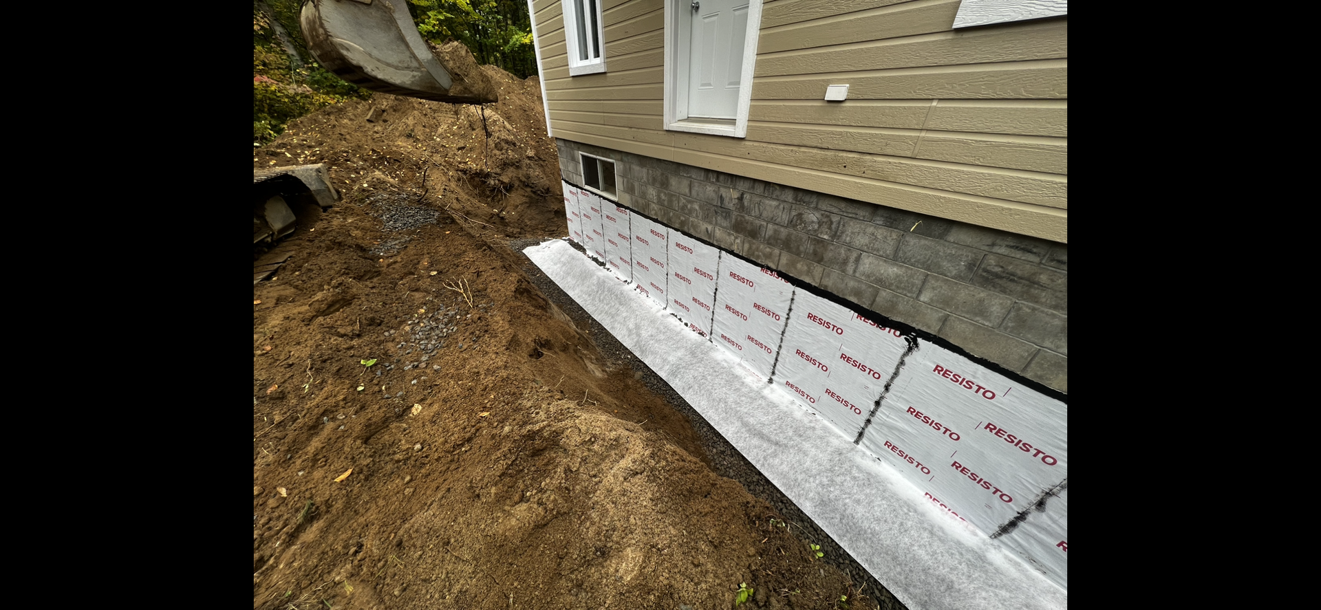 Une maison est en construction au sommet d’une colline de terre.
