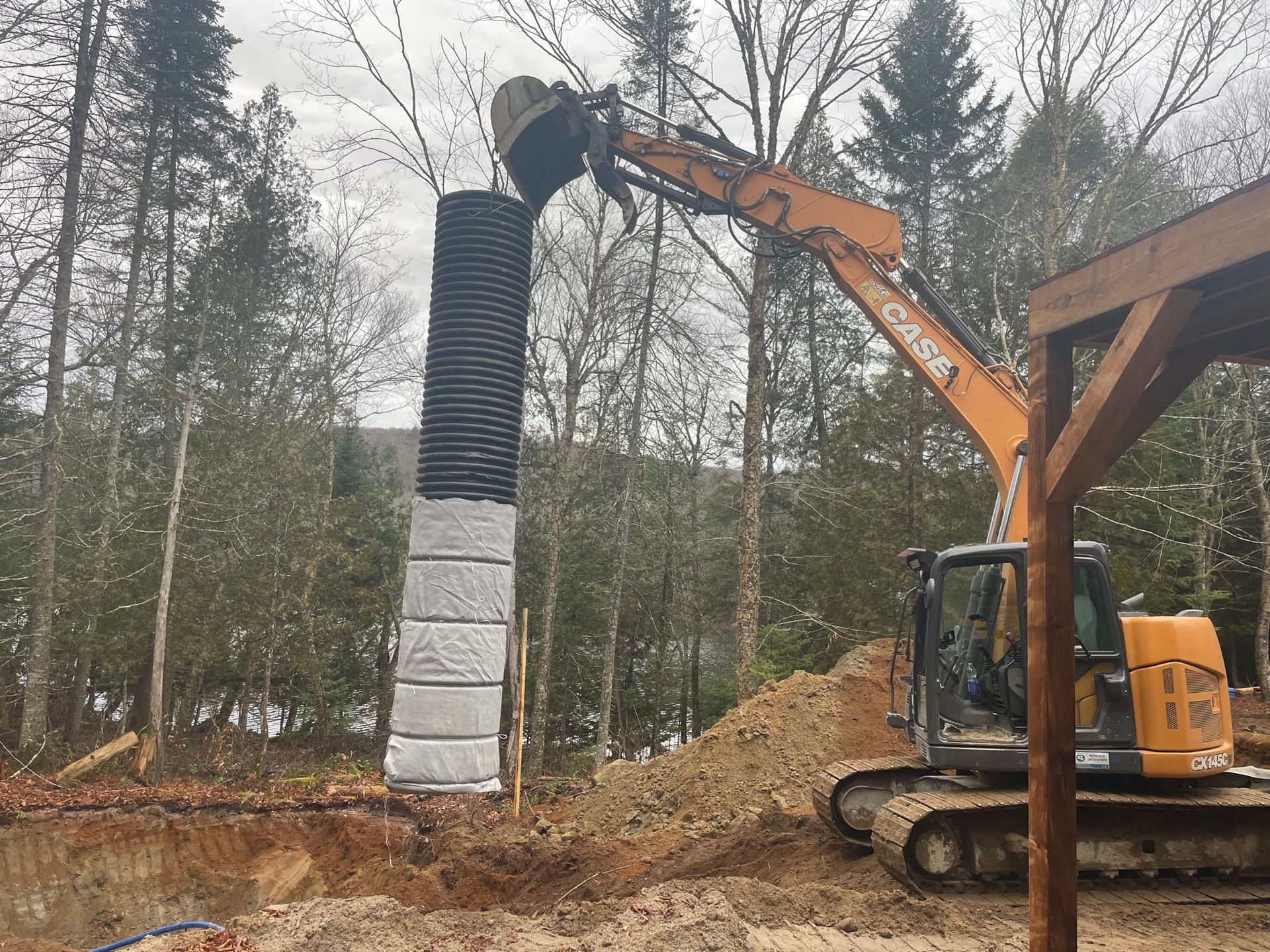 Une grande excavatrice travaille sur un chantier de construction dans les bois.