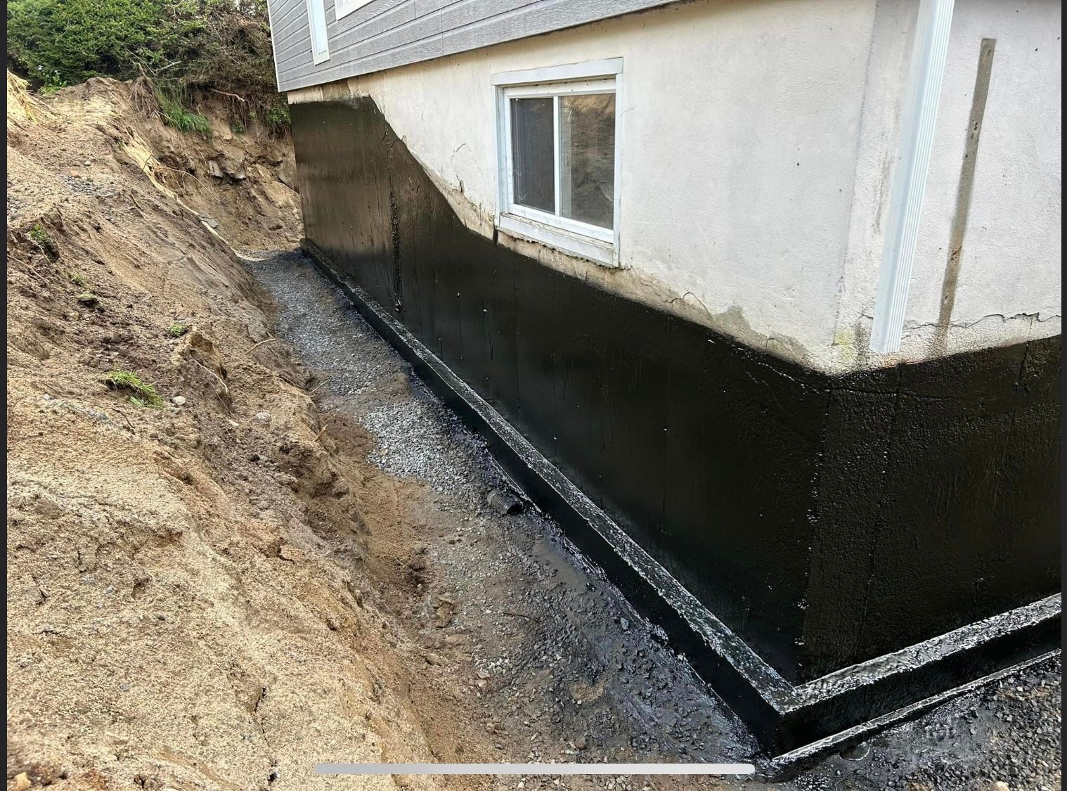 Les fondations d’une maison sont imperméabilisées avec de la peinture noire.