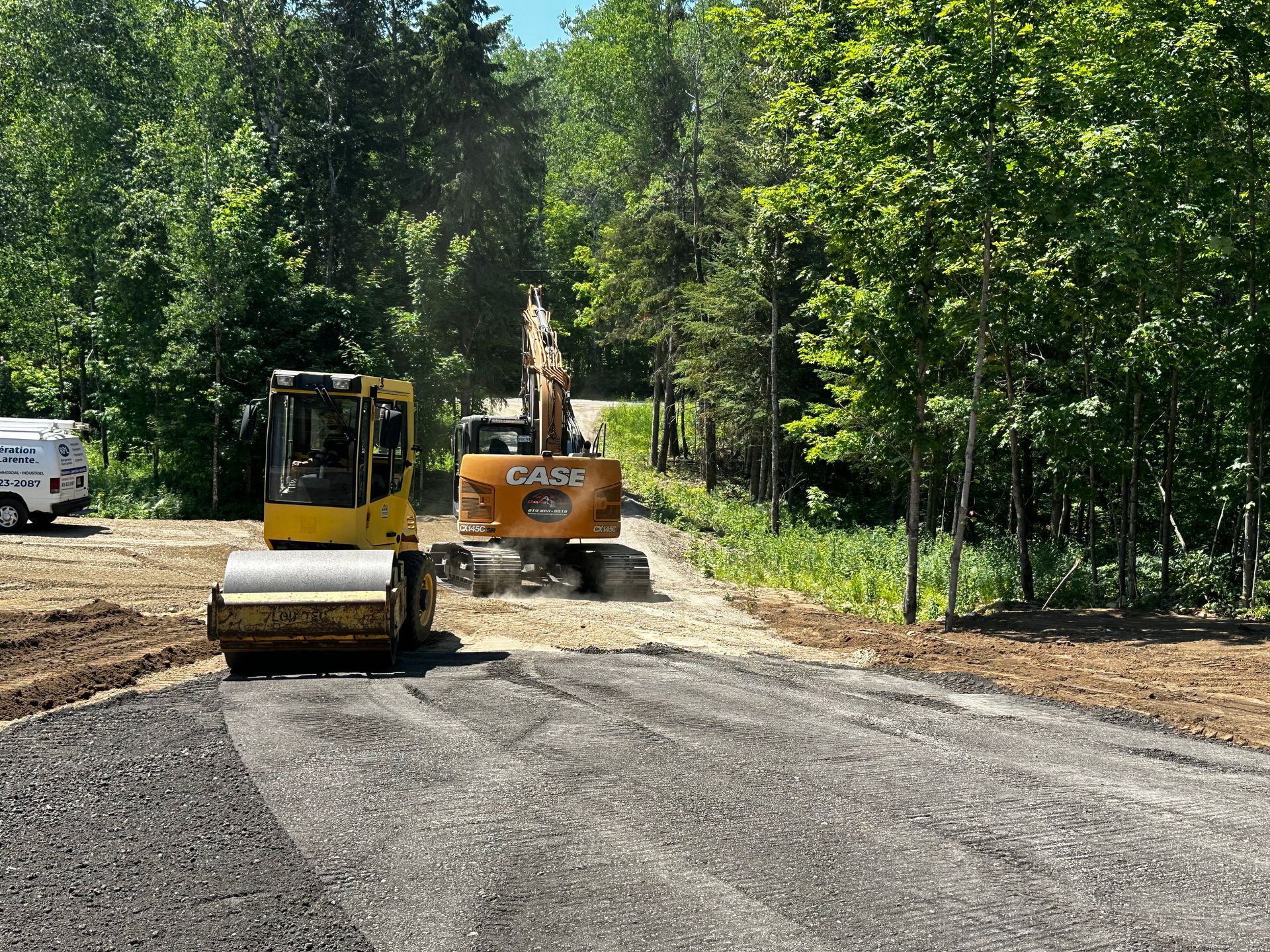 Quelques véhicules de construction travaillent sur une route.