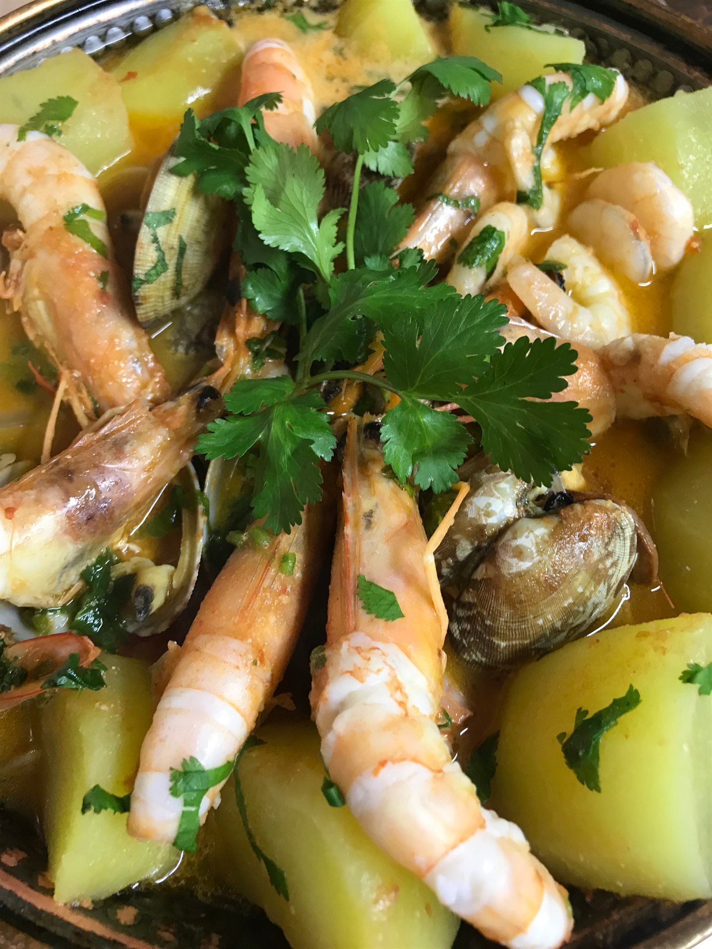 Um close de um prato de comida com camarão e batatas.