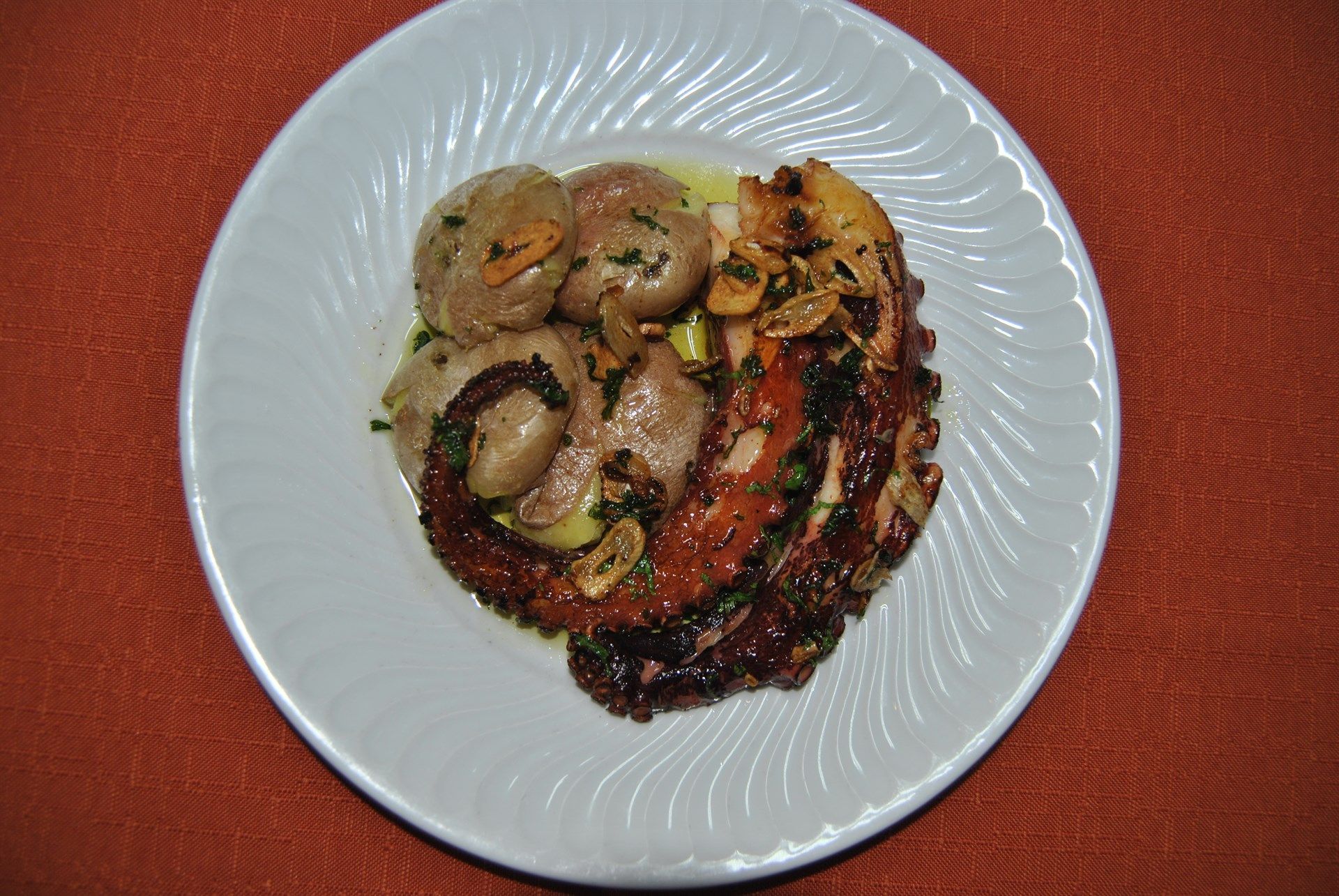 Um prato branco coberto com carne e vegetais sobre uma mesa.