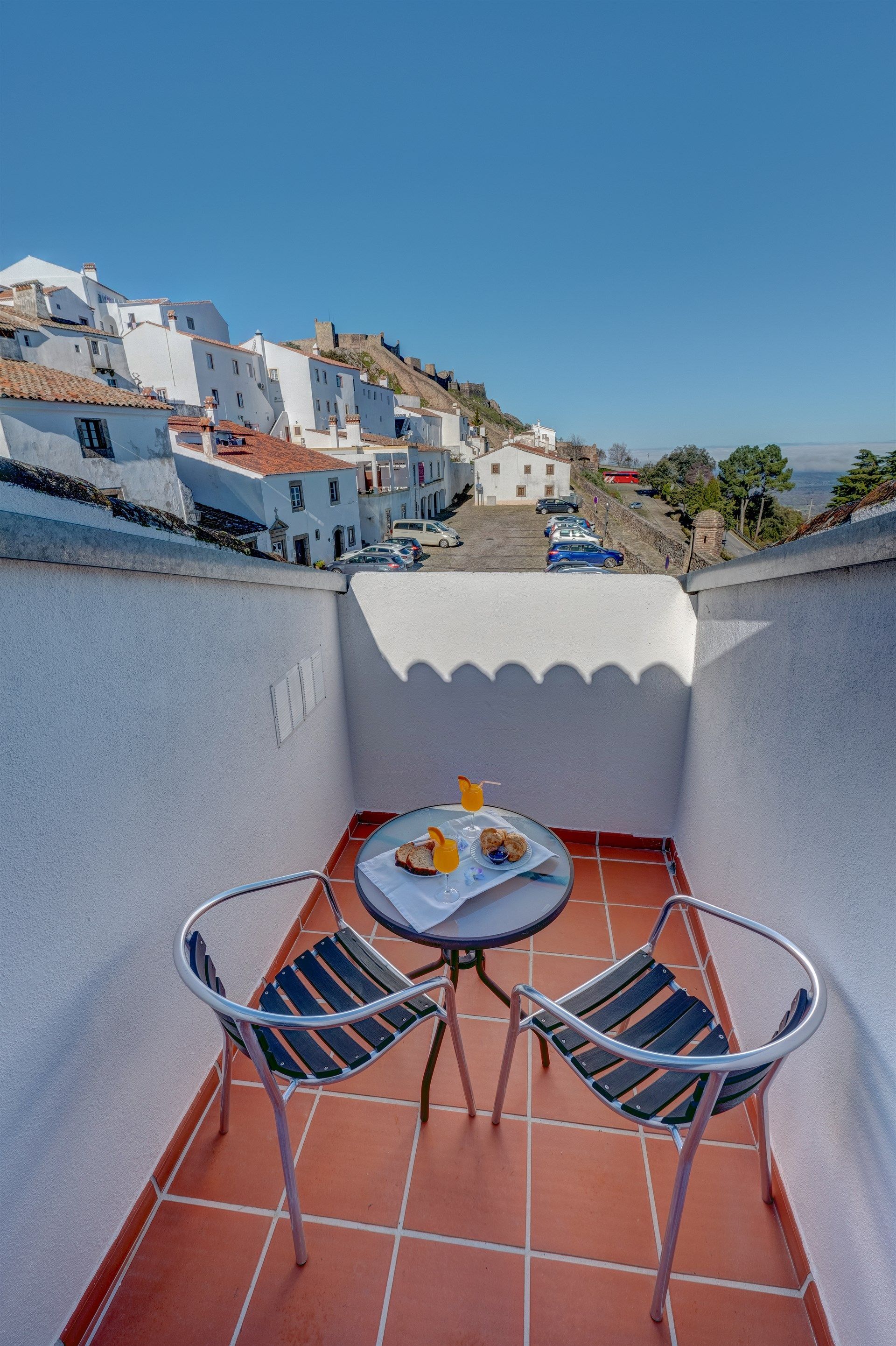 Uma varanda com mesa e cadeiras com vista para a cidade. Hotel El Rei Dom Manuel