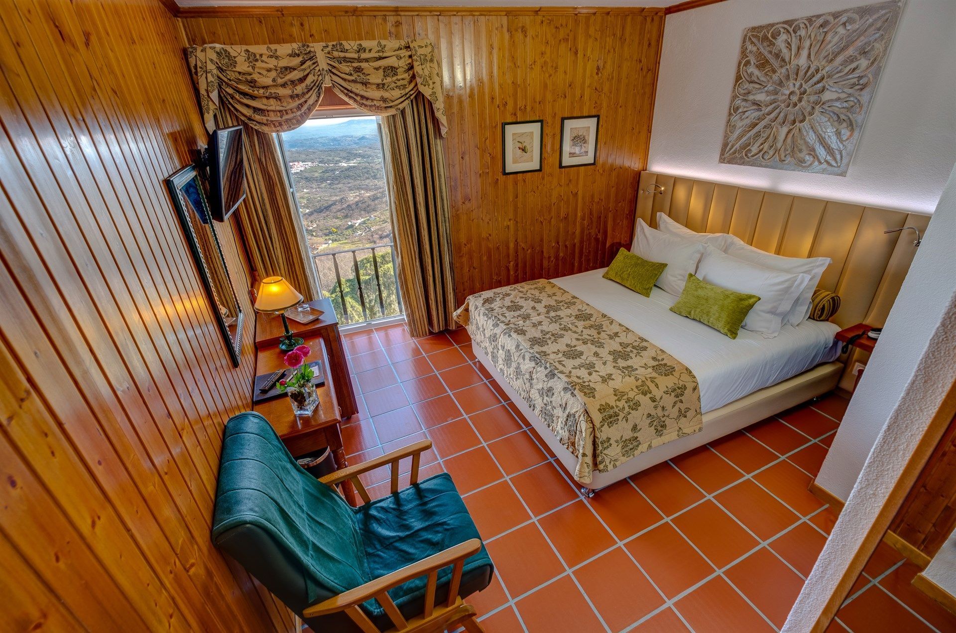 Um quarto de hotel com uma cama, cadeira e televisão. Hotel El Rei Dom Manuel