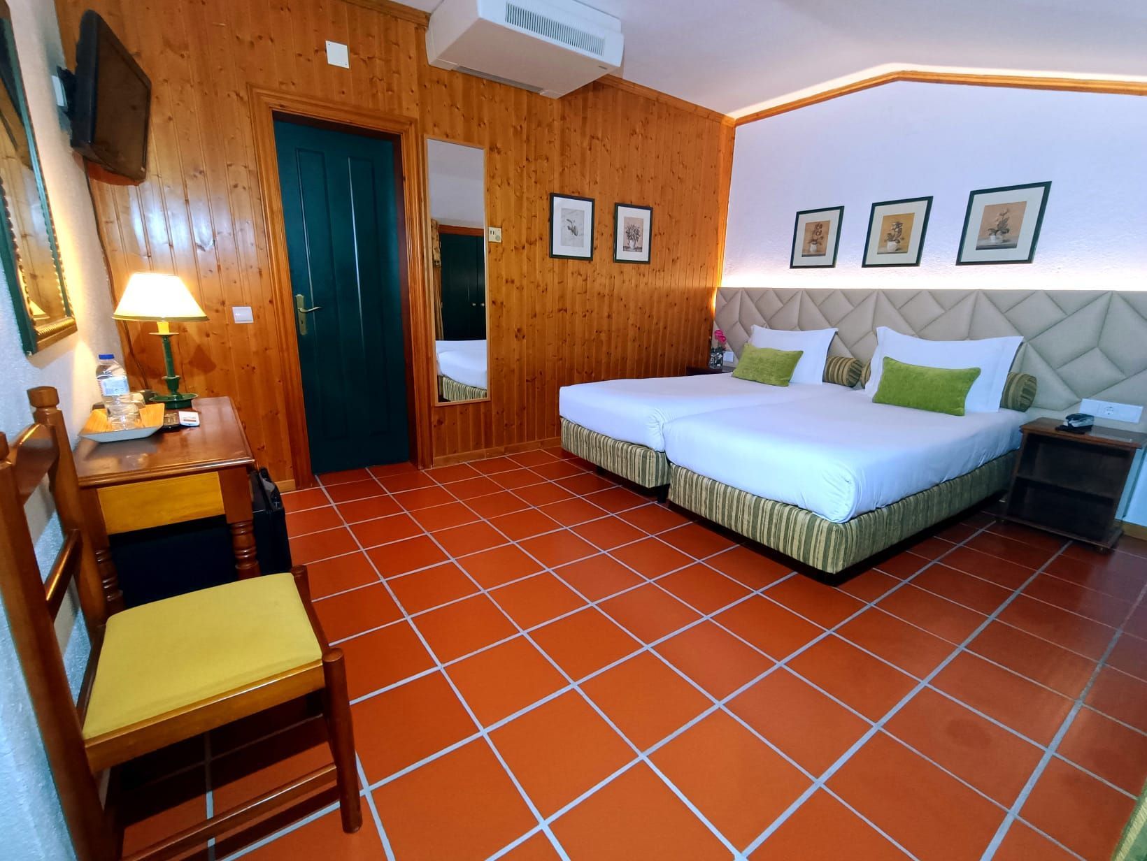 Um quarto de hotel com duas camas e uma cadeira