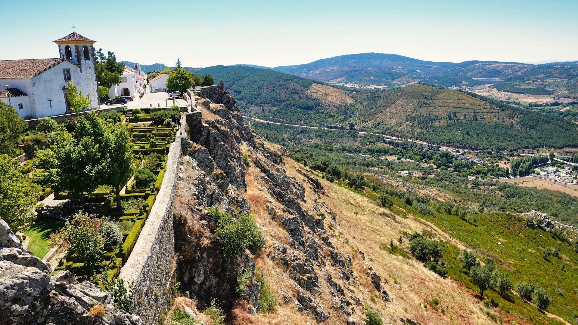 Há um edifício no topo de uma colina com vista para um vale. Marvão 