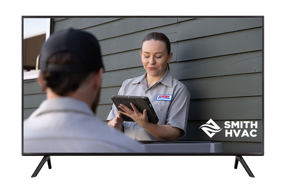 TV screen showing HVAC technician with tablet, talking to a customer outside a home; Smith HVAC logo visible.