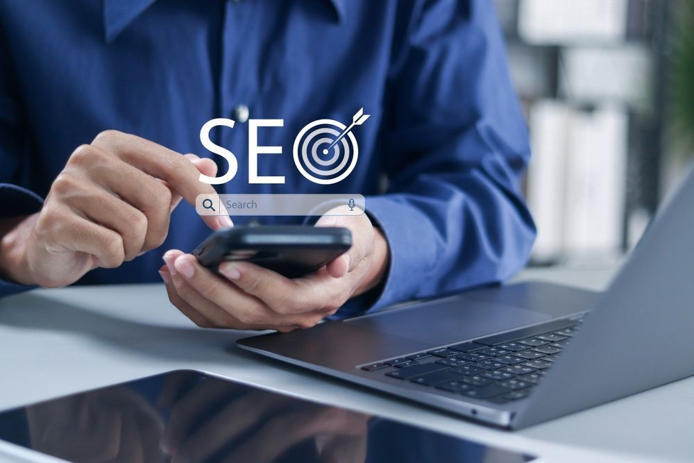 Person using a smartphone and laptop; 