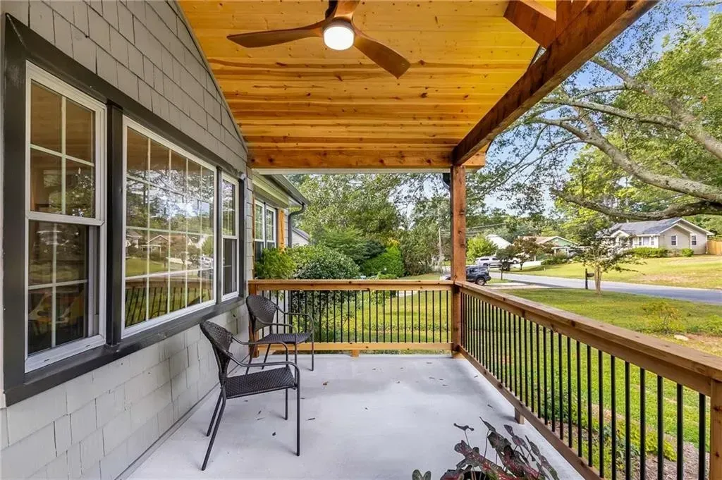 There is a ceiling fan on the porch of a house.