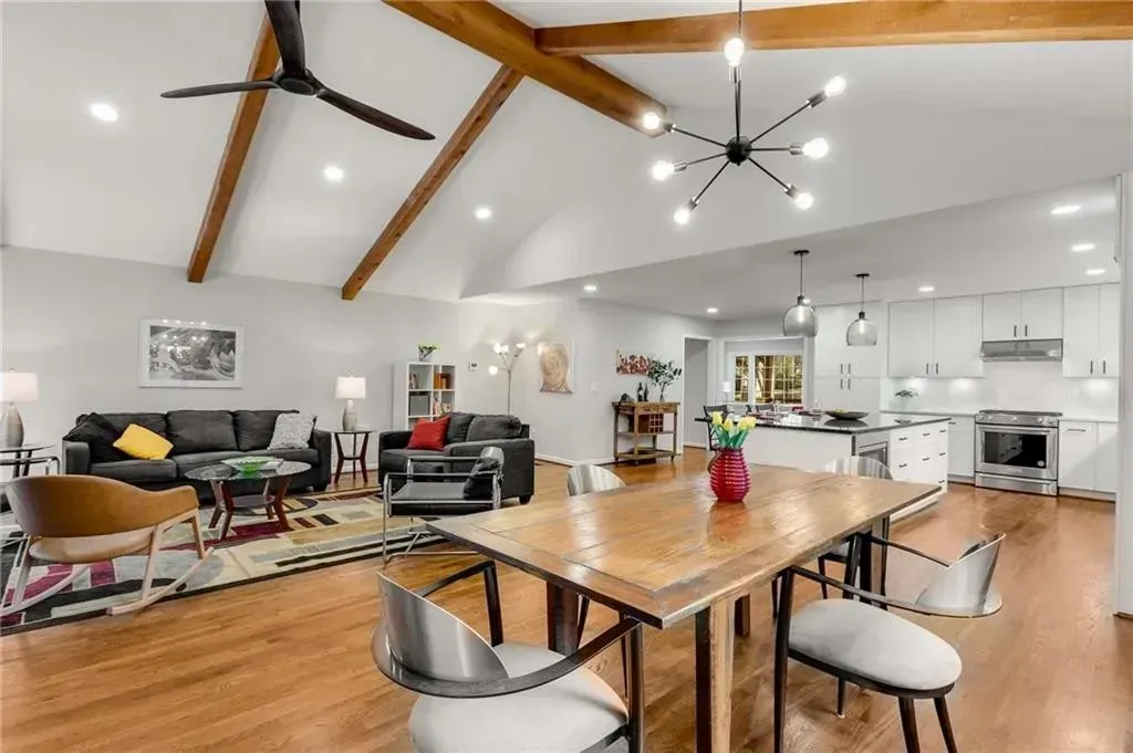 A living room with a table and chairs and a ceiling fan