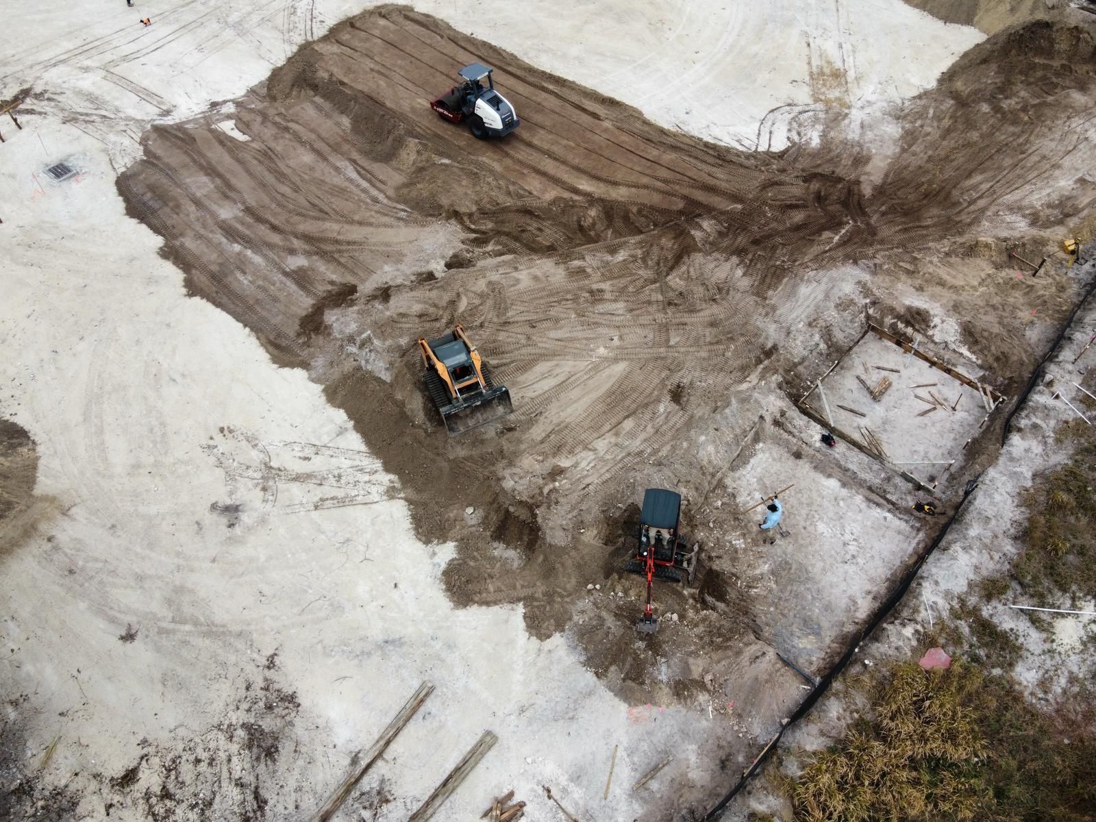 An aerial view of a construction site with tractors moving dirt.