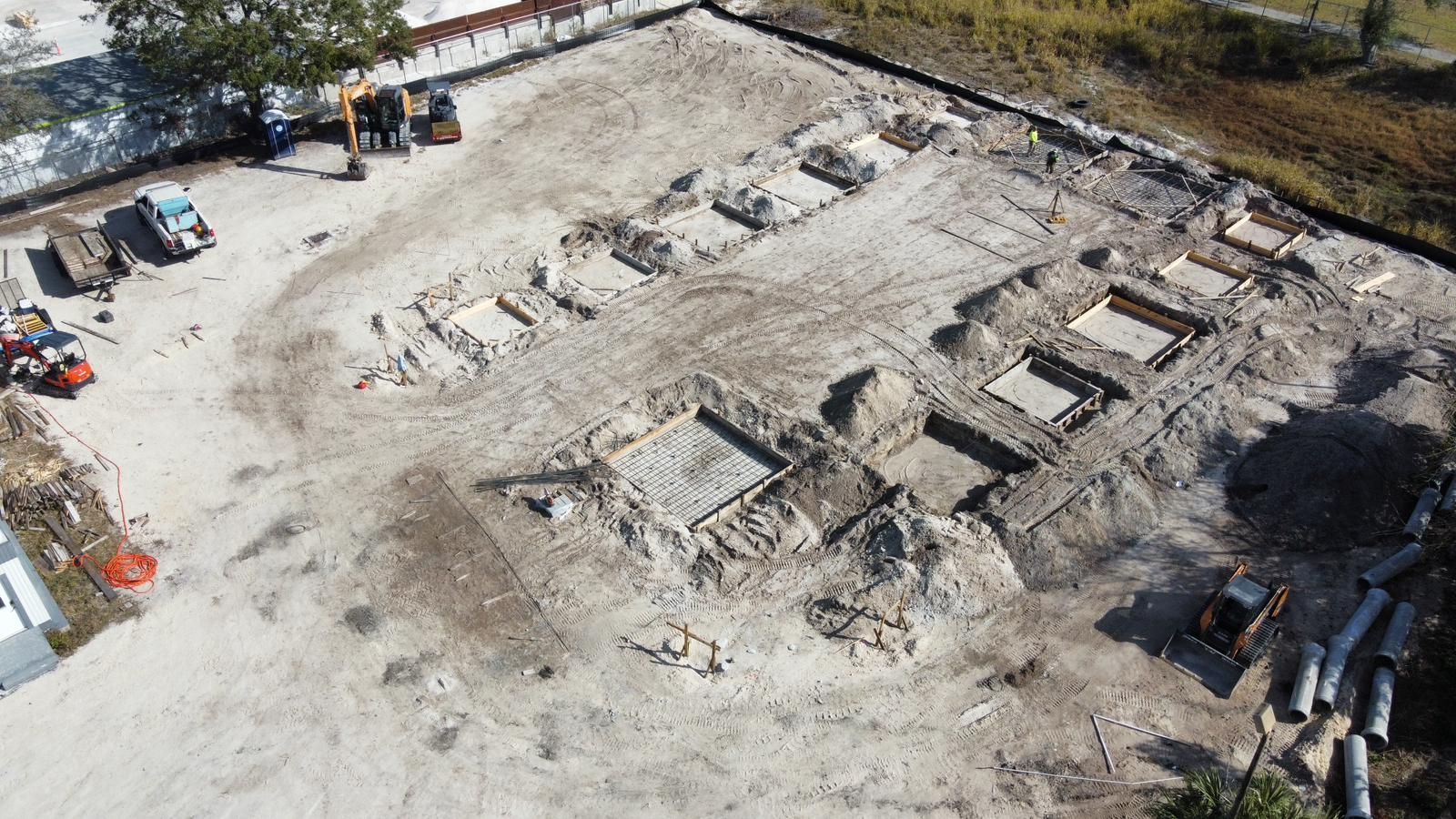 An aerial view of a construction site with a lot of machinery in the dirt.
