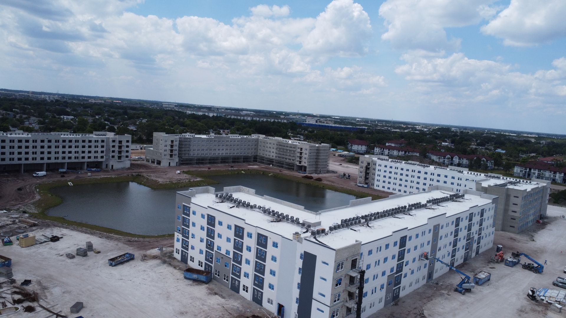 An aerial view of a large building under construction next to a lake.