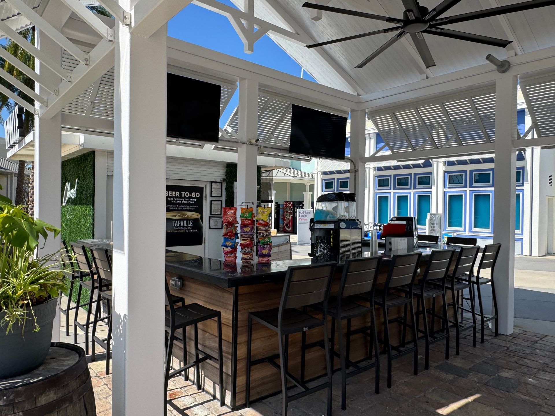 A restaurant with a long bar and a ceiling fan