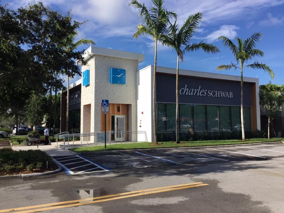 A charles schwab store with palm trees in front of it