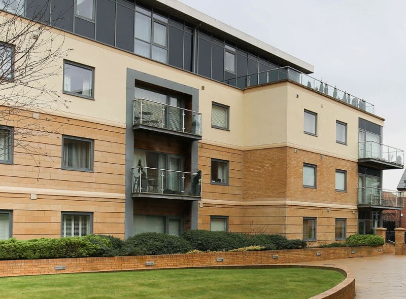 A large apartment building with a lot of windows and balconies.