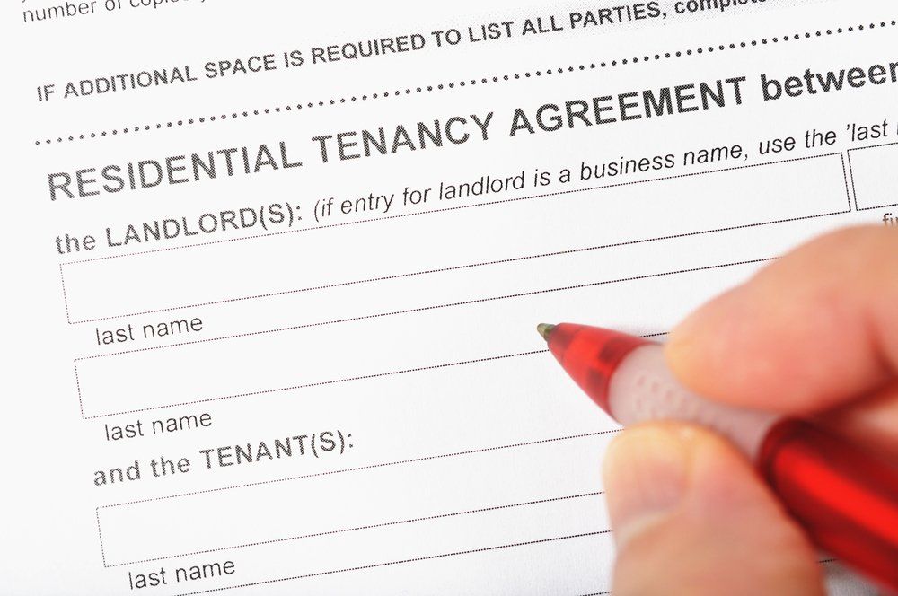 A person is filling out a residential tenancy agreement