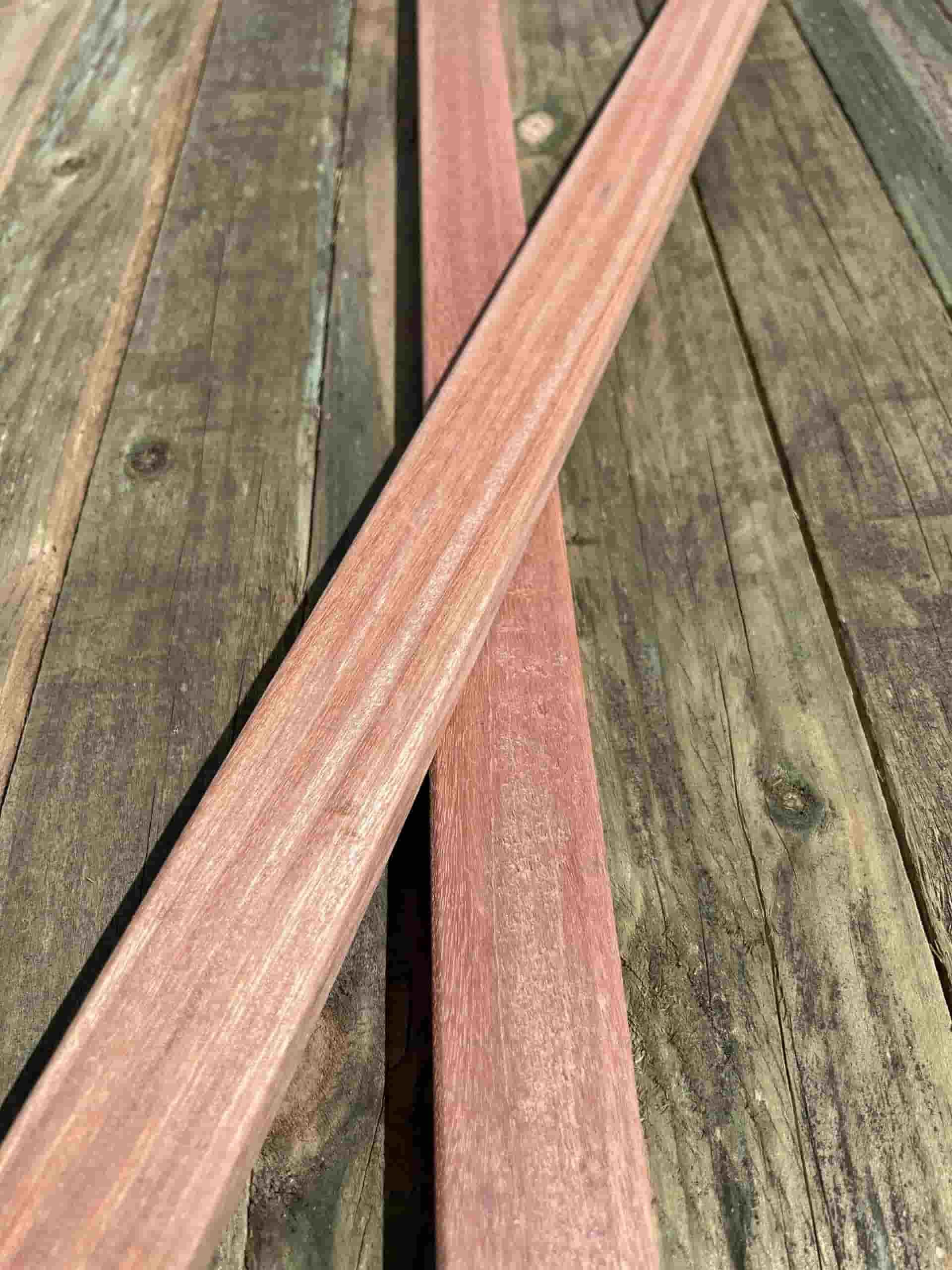 Two Wooden Sticks Are Crossed Over Each Other on a Wooden Table — B & B Timbers Ballina In West Ballina, NSW