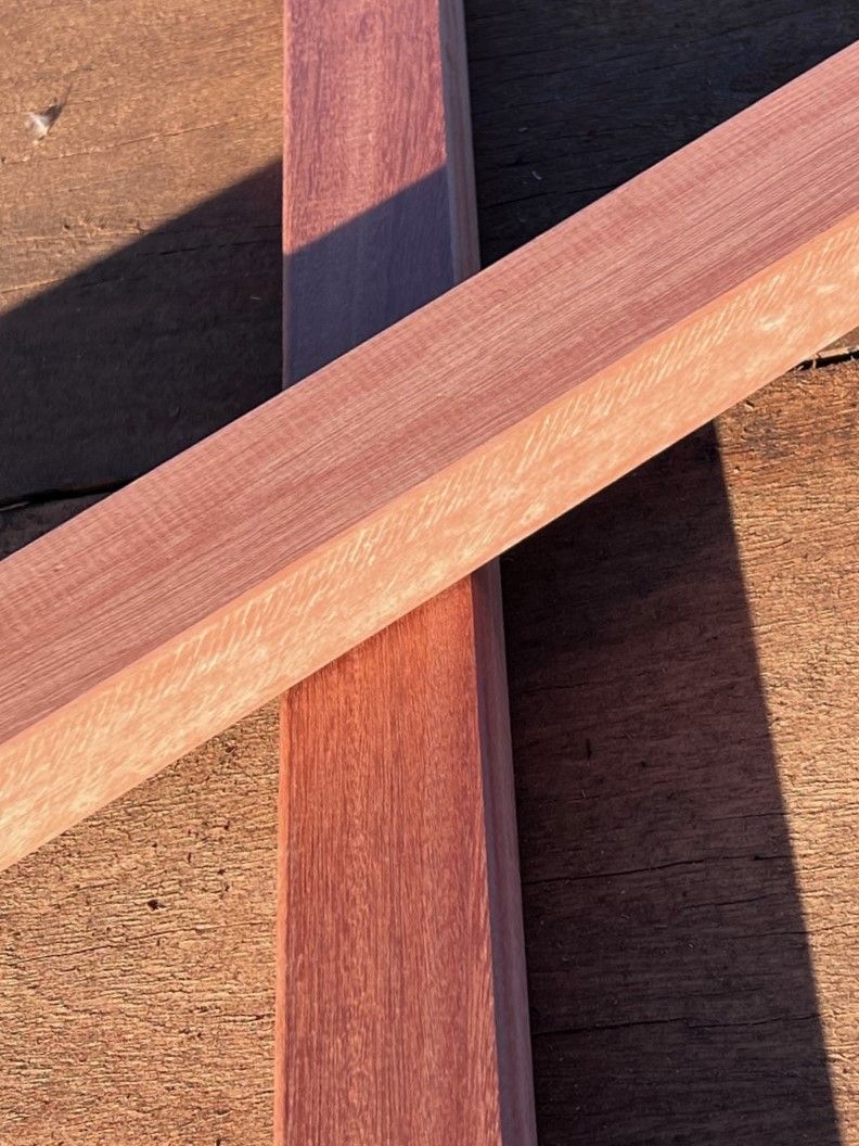 Two Wooden Sticks Are Crossed Over Each Other on a Wooden Surface — B & B Timbers Ballina In West Ballina, NSW