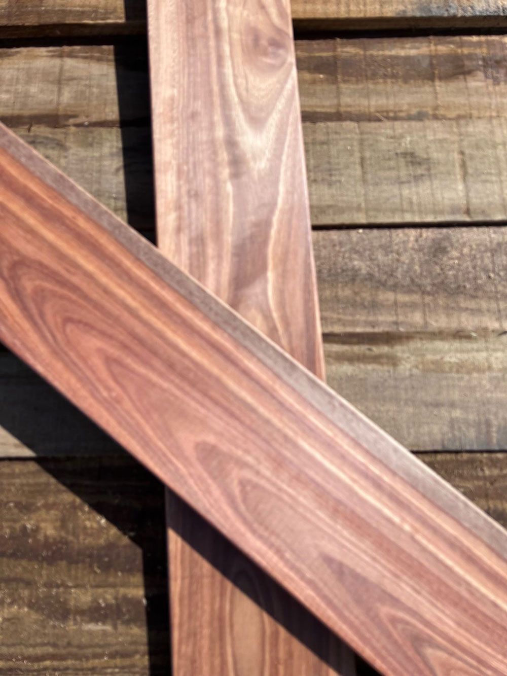 Two Pieces of Wood Are Crossed Over Each Other on a Wooden Surface — B & B Timbers Ballina In West Ballina, NSW