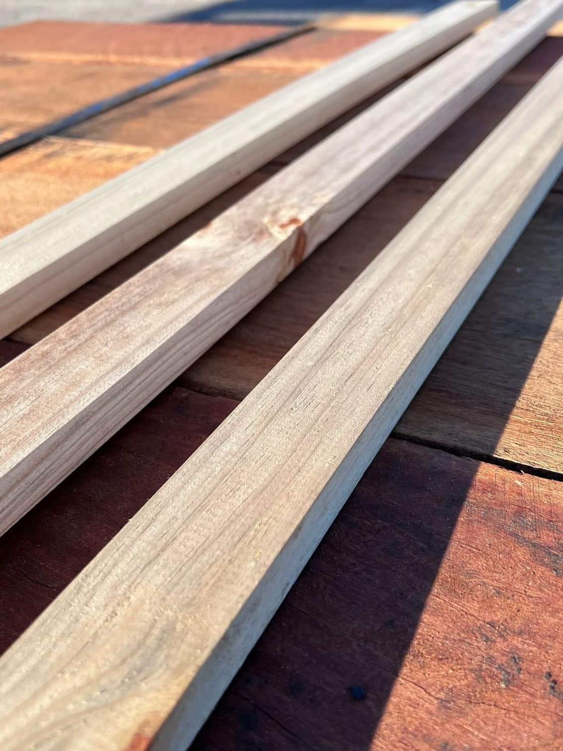 Three Pieces of Wood Are Laying on a Brick Floor — B & B Timbers Ballina In West Ballina, NSW
