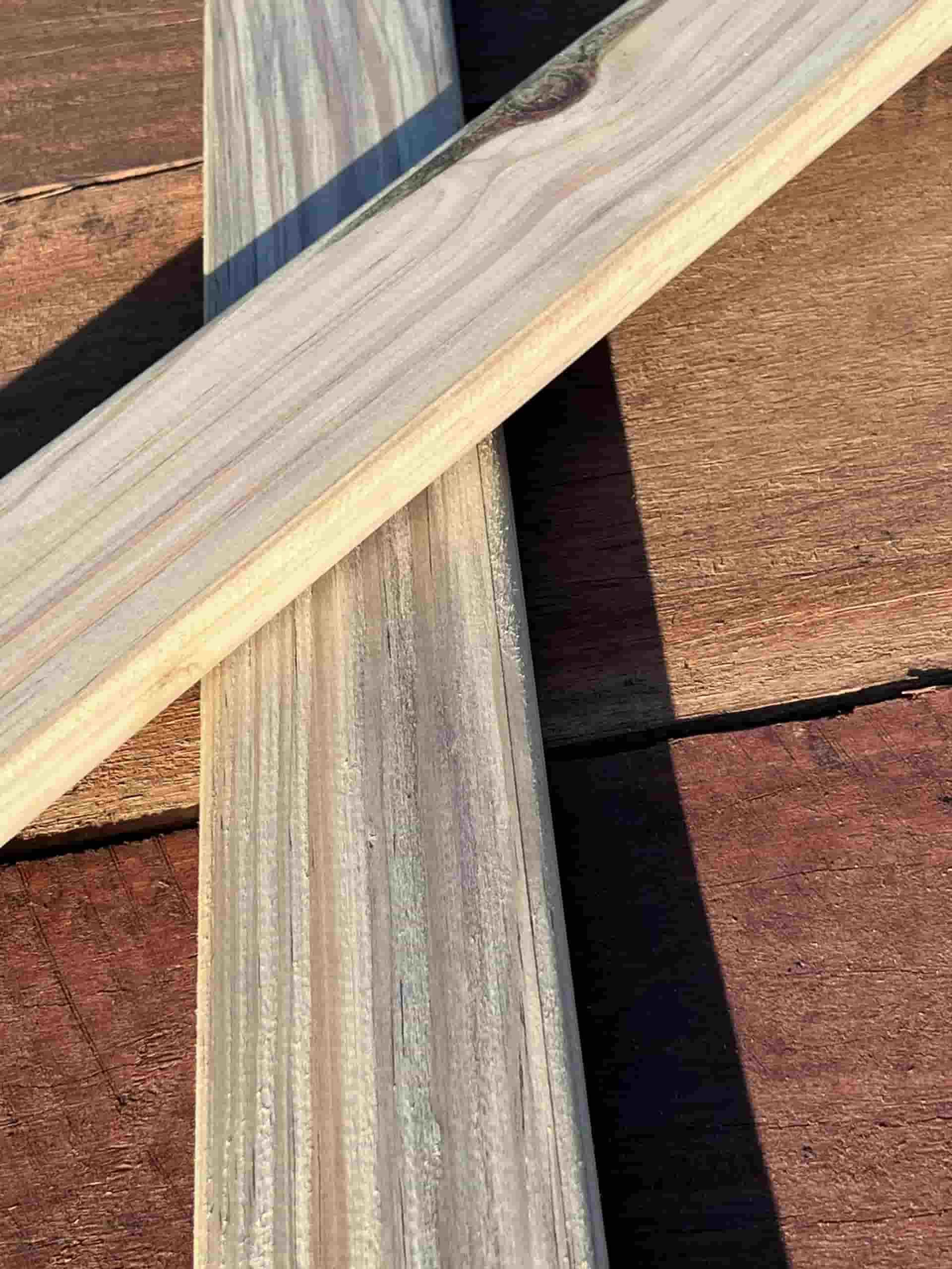 Two Wooden Boards Are Crossed Over Each Other on a Brick Floor — B & B Timbers Ballina In West Ballina, NSW