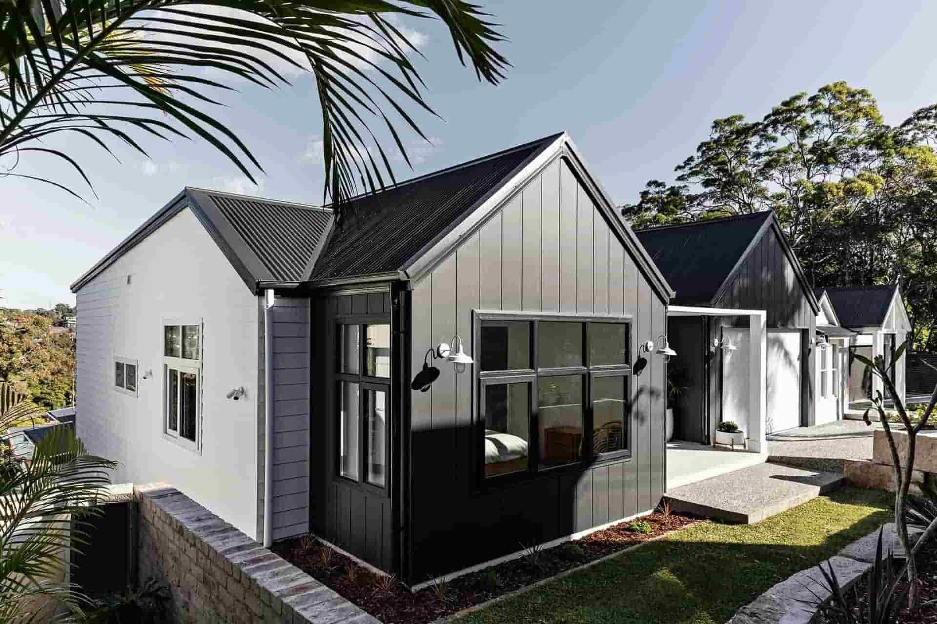 A White House With a Black Roof and a Palm Tree in the Background — B & B Timbers Ballina In West Ballina, NSW