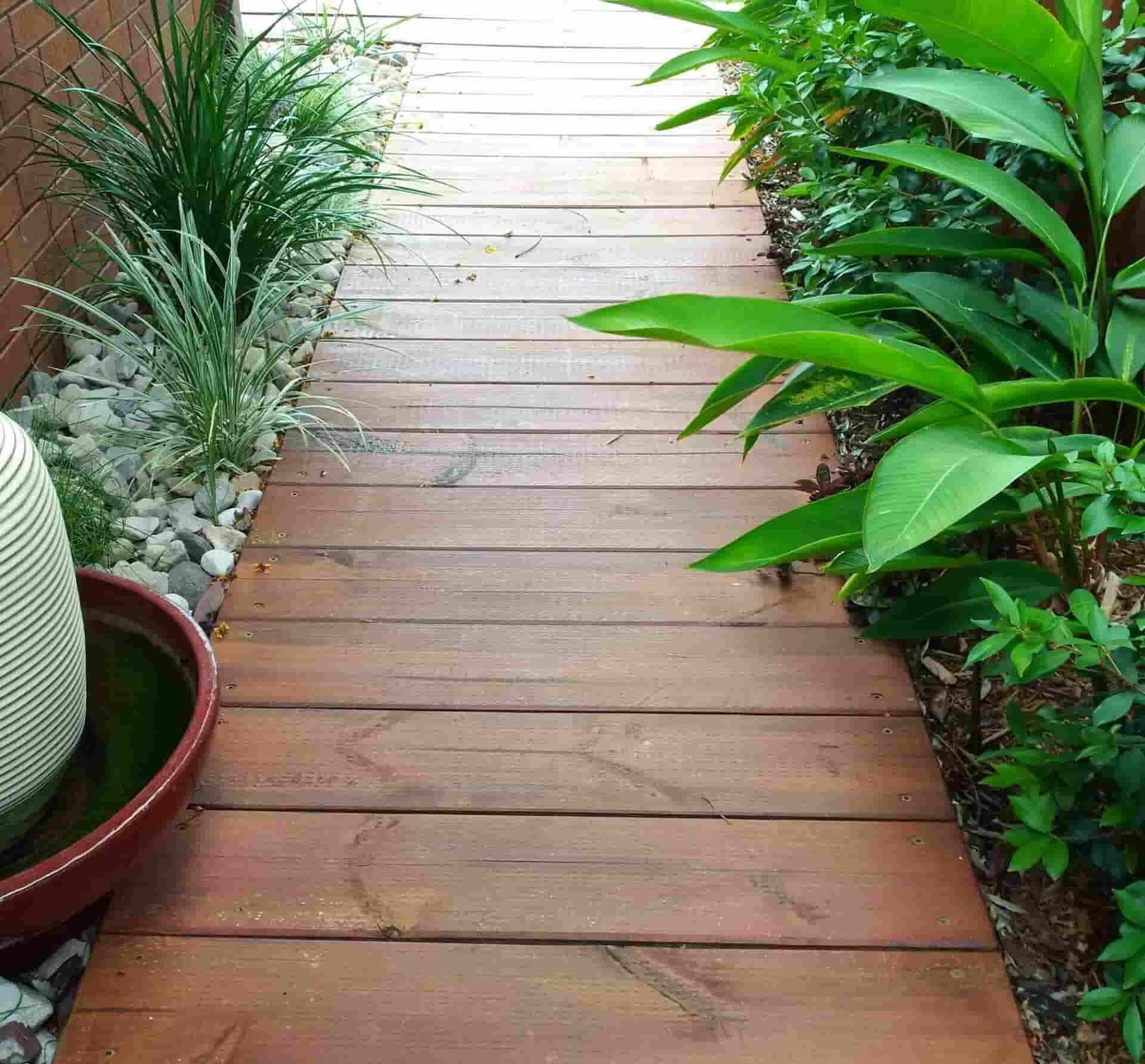 A Wooden Walkway Surrounded by Plants and Rocks — B & B Timbers Ballina In West Ballina, NSW