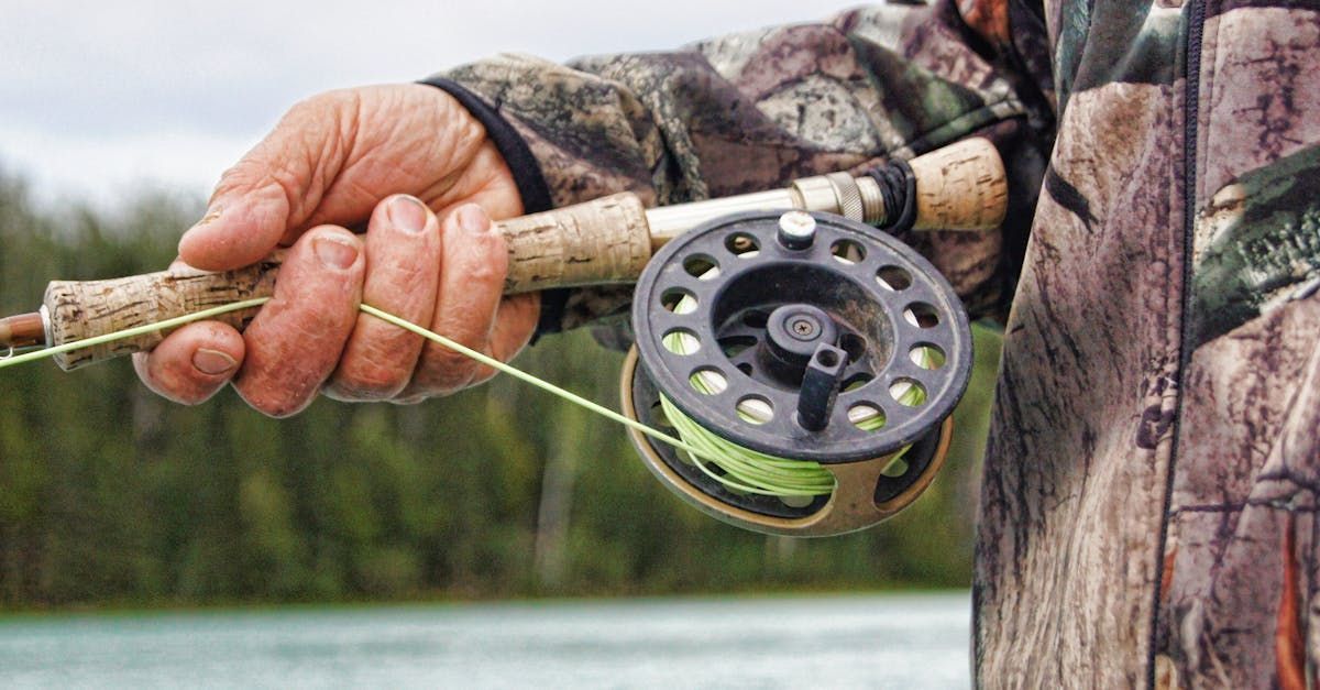 A man is holding a fly fishing rod in his hand.