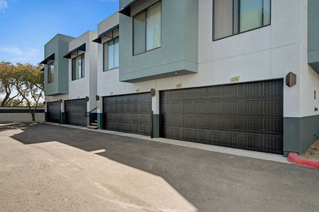 A row of garage doors are lined up in front of a building.
