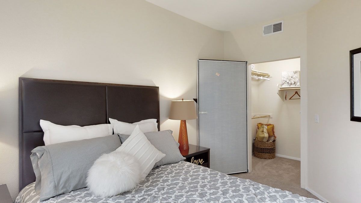 A bedroom with a large bed and a walk in closet.