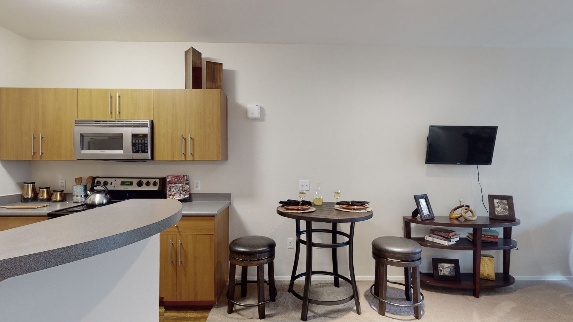 A kitchen with a table and stools in it