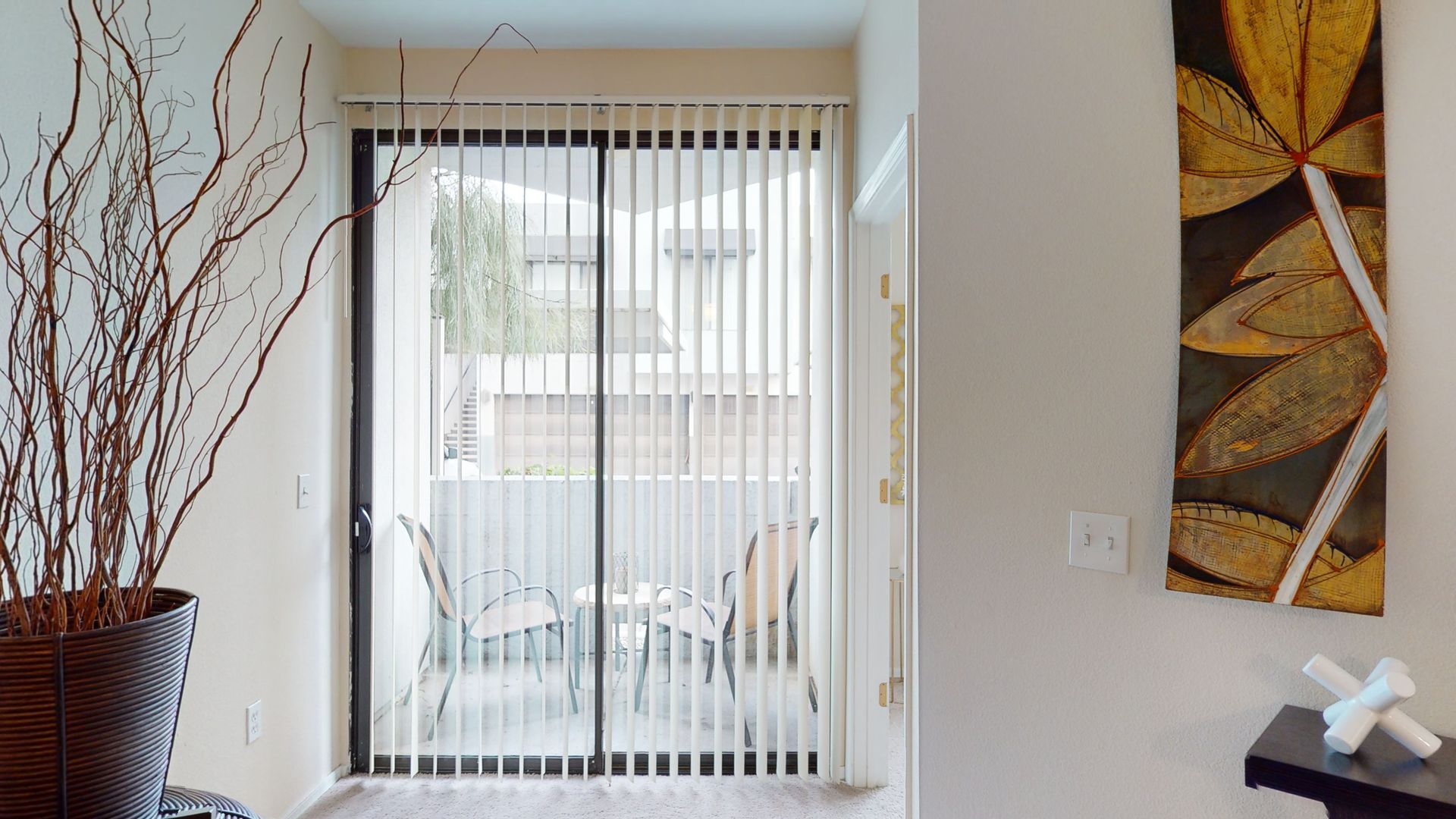 A living room with a sliding glass door leading to a balcony.