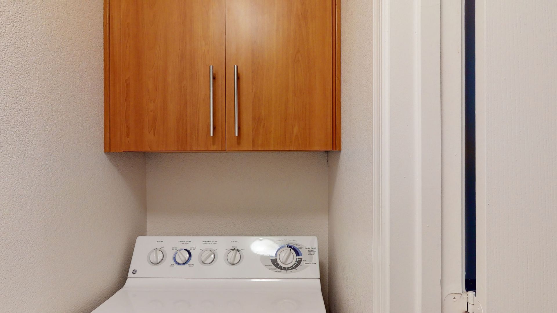 A washer and dryer are mounted to the wall in a laundry room.