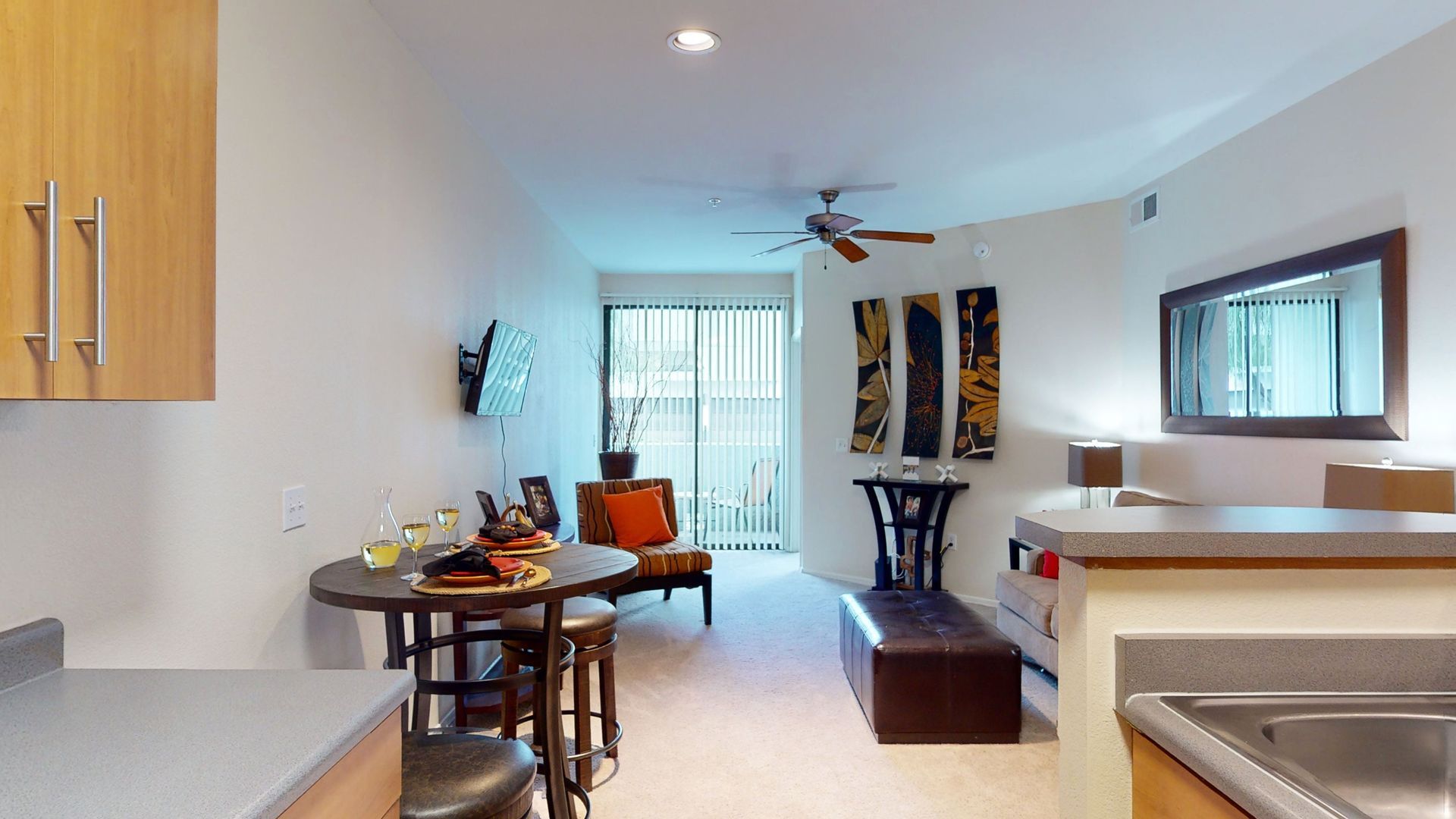 A living room with a table and chairs and a sliding glass door.