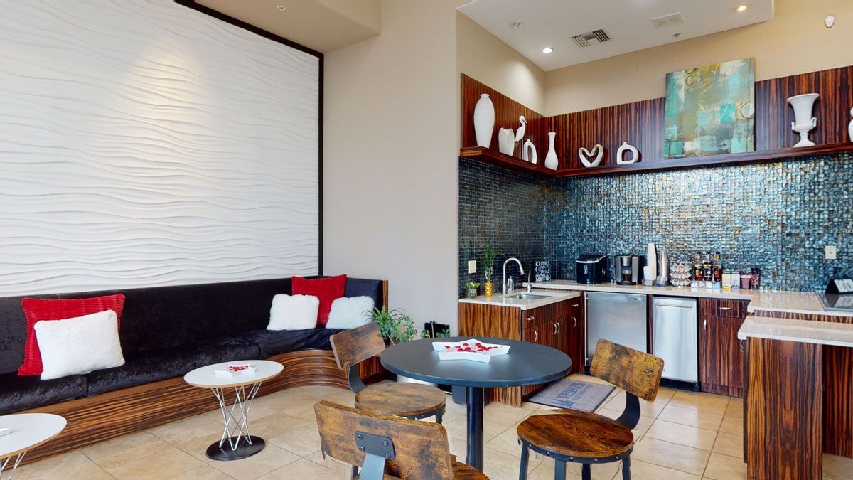 A living room with a table and chairs and a kitchen.